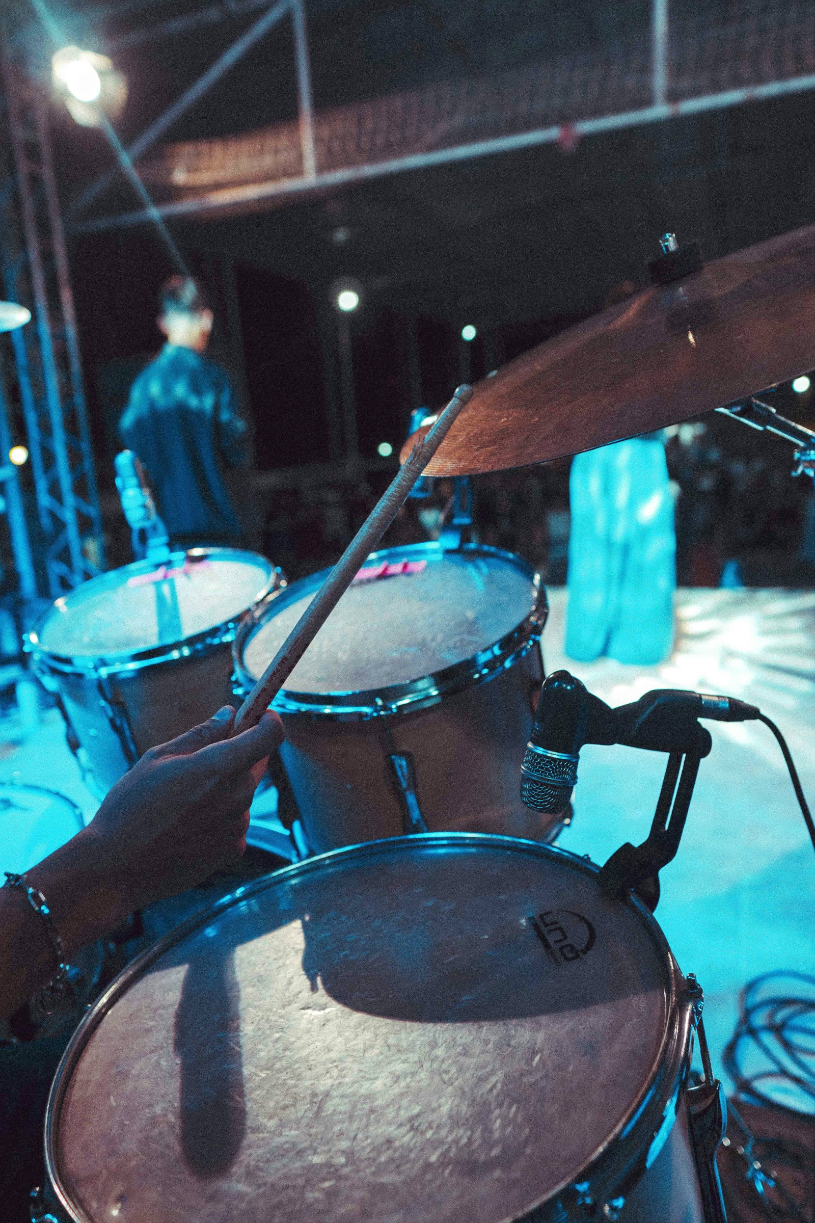 Drummer playing a drum kit on stage under performance lights, echoing how music and a single dramatic fill powered the Cadbury Gorilla ad.