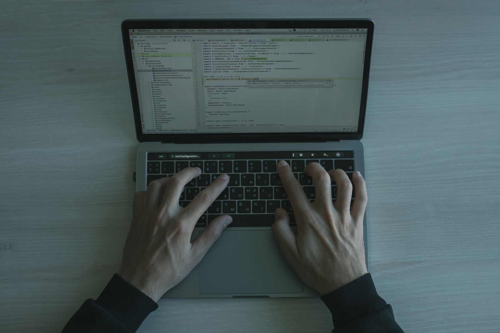 Hands typing on a laptop keyboard on a wooden desk, representing an advertiser setting up a ChatGPT Ads test campaign in Ads Manager.
