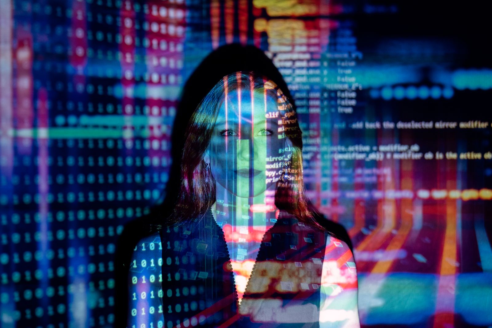 A woman with digital code and data charts projected across her face against a dark background, representing AI-native advertising and ChatGPT Ads.