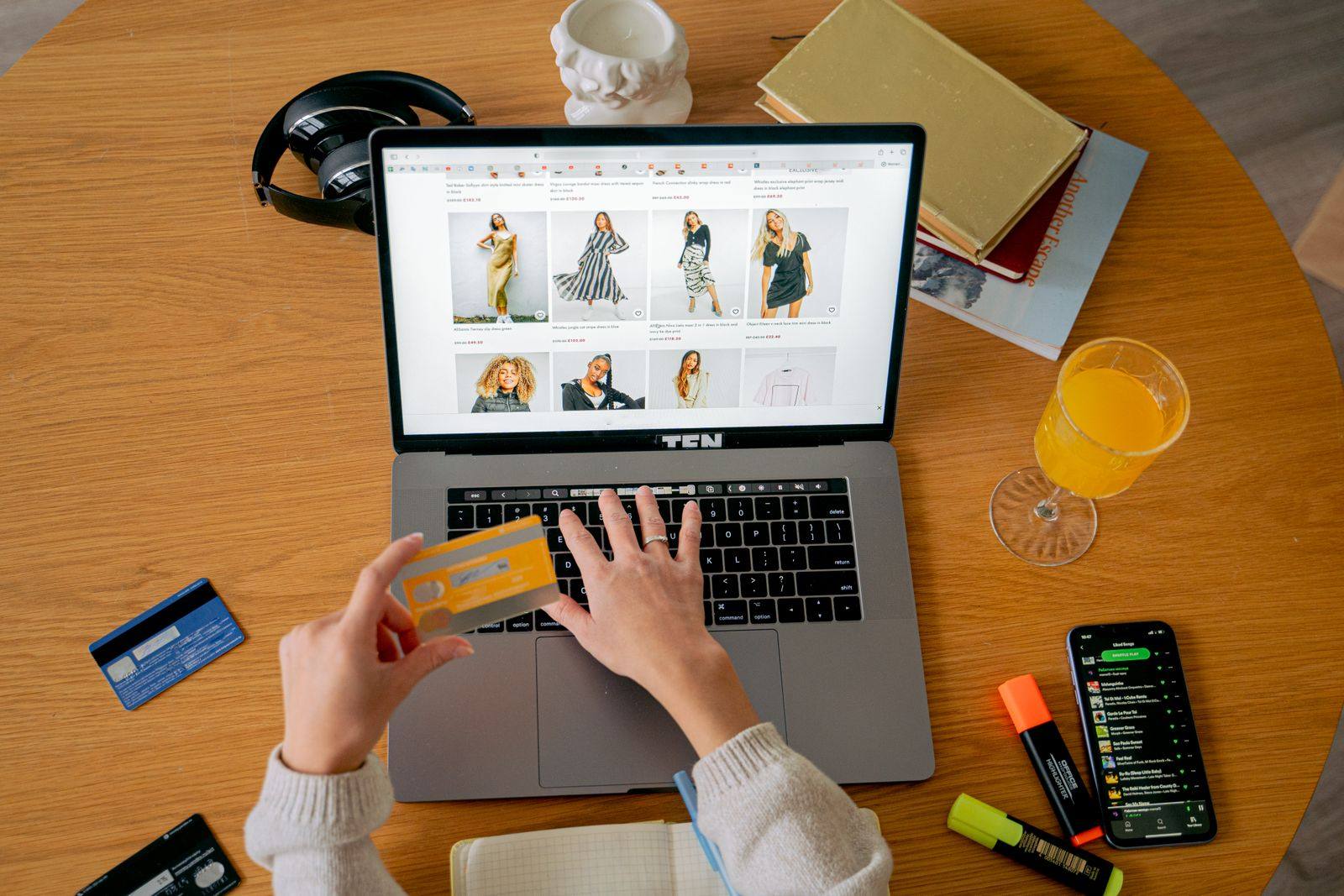 Hands holding a bank card while making an online purchase on a laptop, a reminder that sales conversions in Google Ads should count every purchase while leads should usually count one.