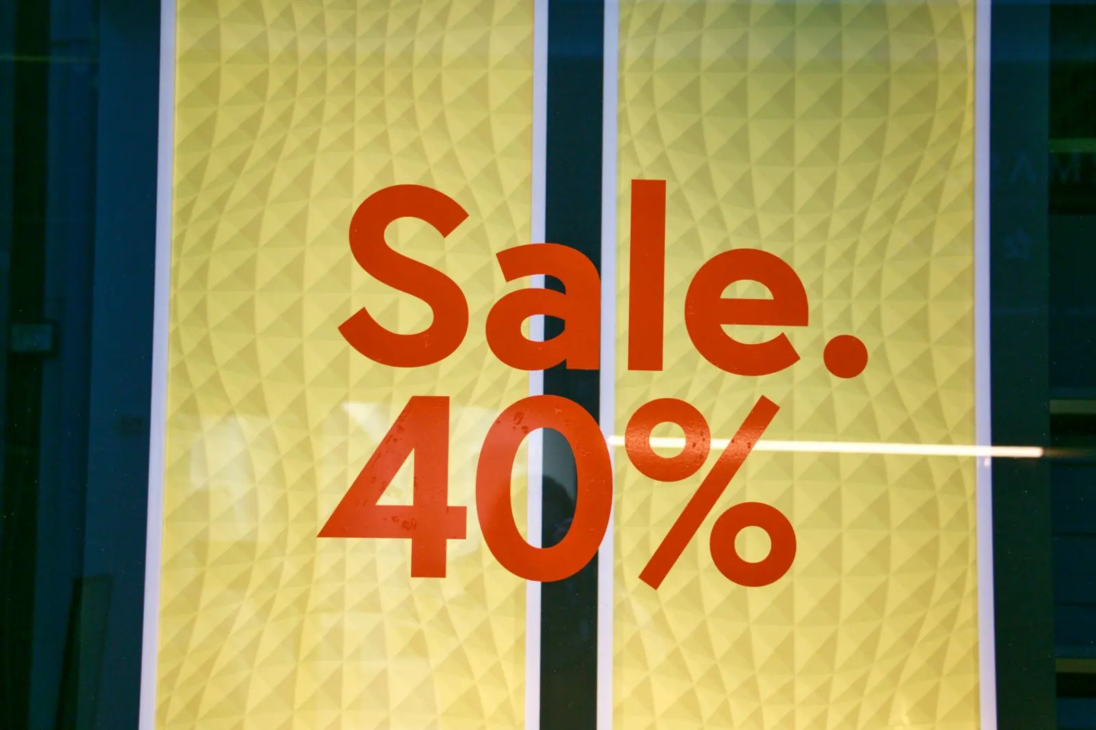 Large red "Sale. 40%" sign on a yellow poster in a shop window, representing a discount offer that could appear in an ad.