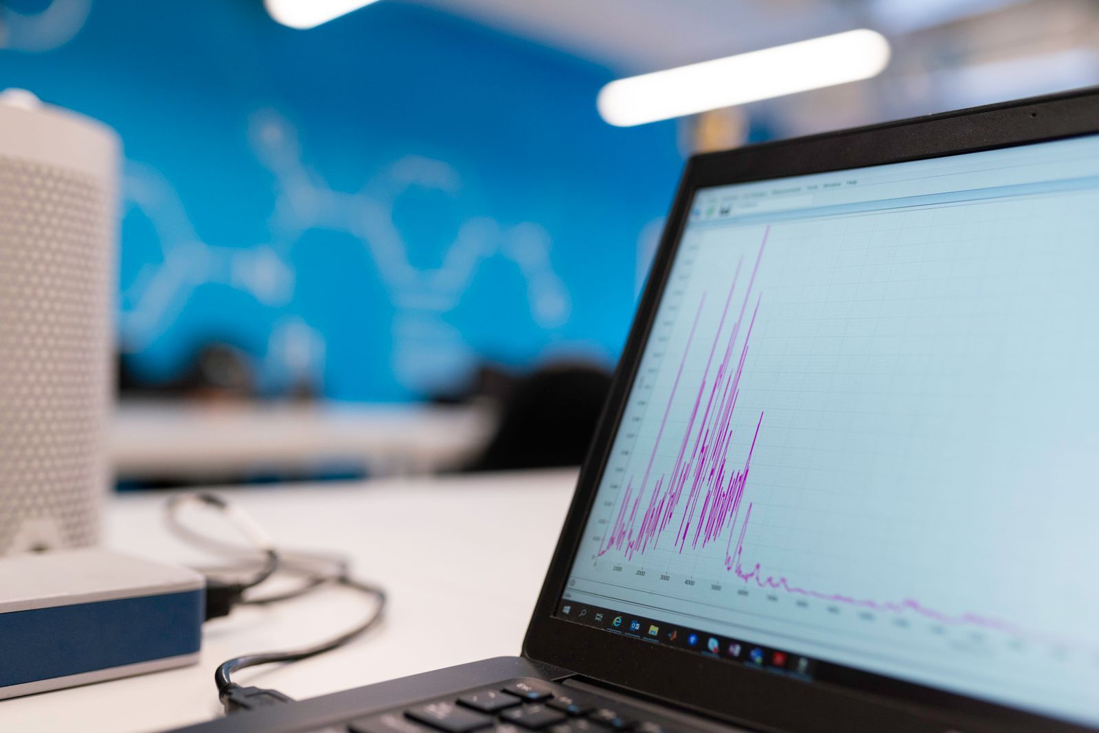 A laptop on an office desk showing a line graph with sharp spikes, the kind of sudden swing UK businesses have been seeing in their SEO rank tracker since September 2026.