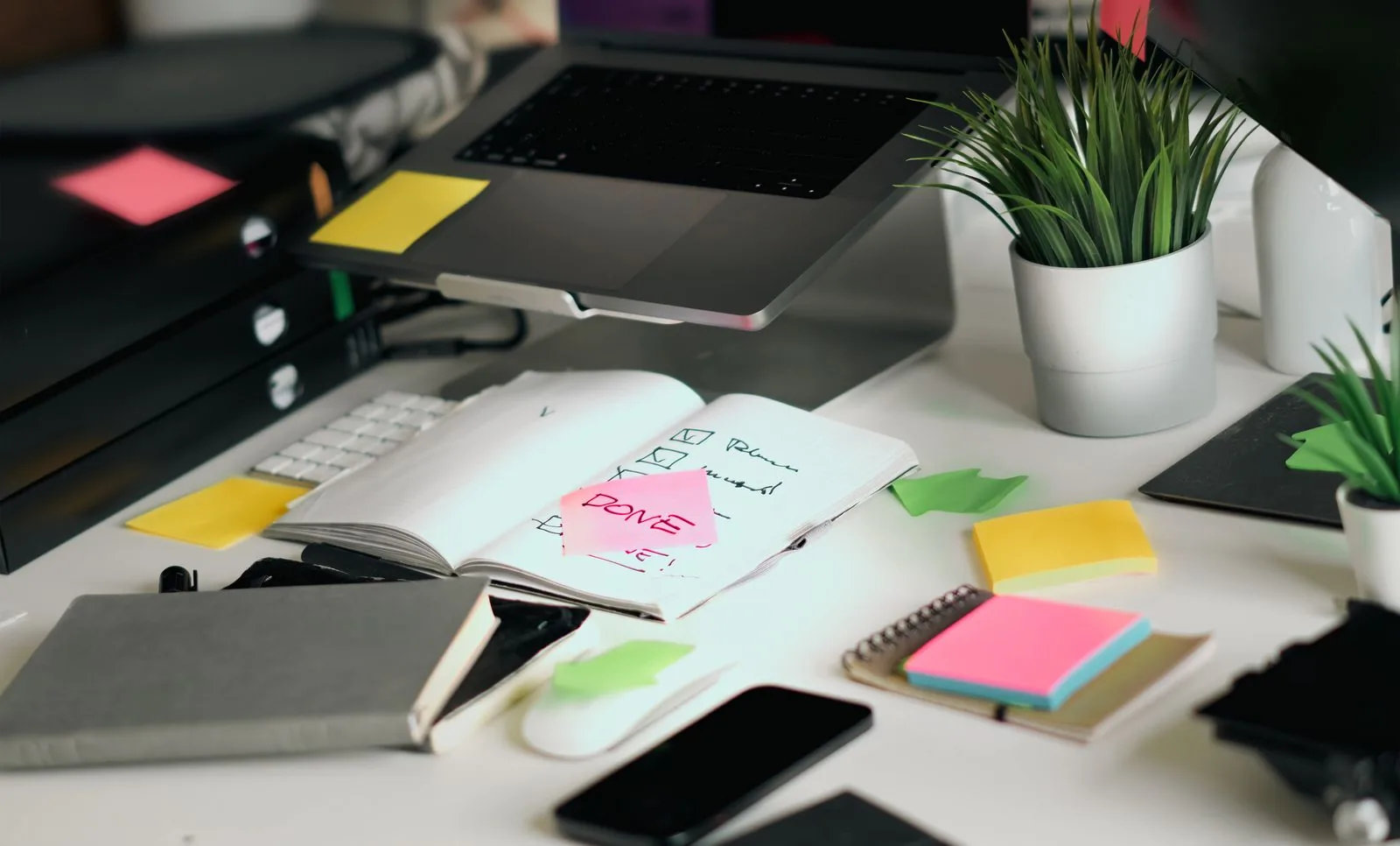 A busy office desk with a laptop, open notebooks, checklists and colourful sticky notes, laid out as a fix plan for recovering from a Google spam update.