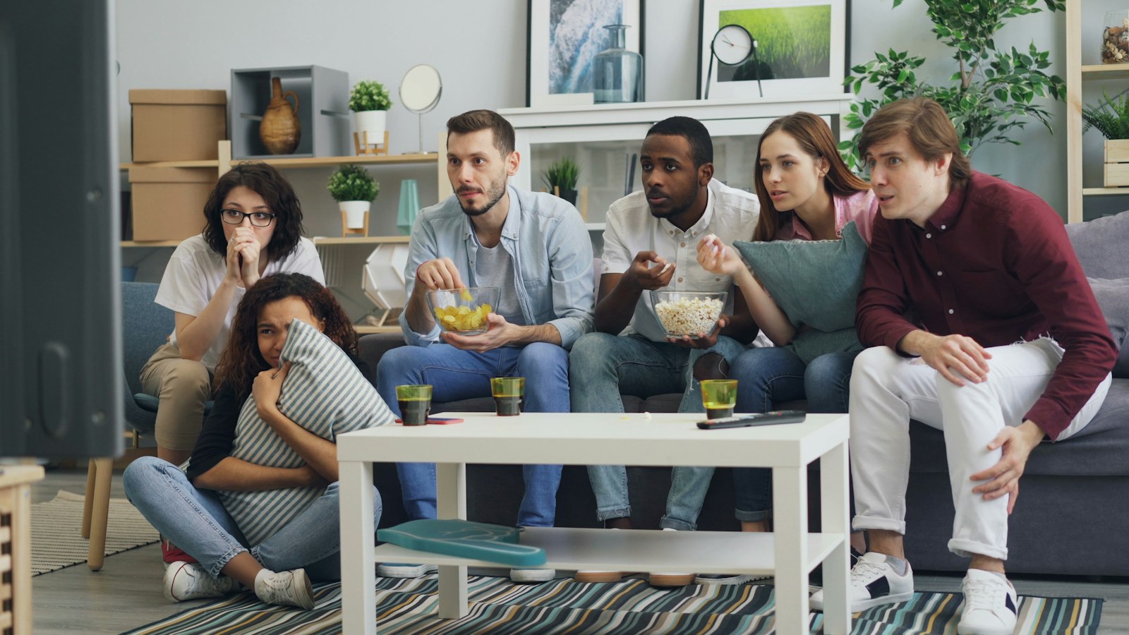 A group of people sitting together on a sofa in a living room, echoing the shared TV moment that made the John Lewis Christmas advert a national event.
