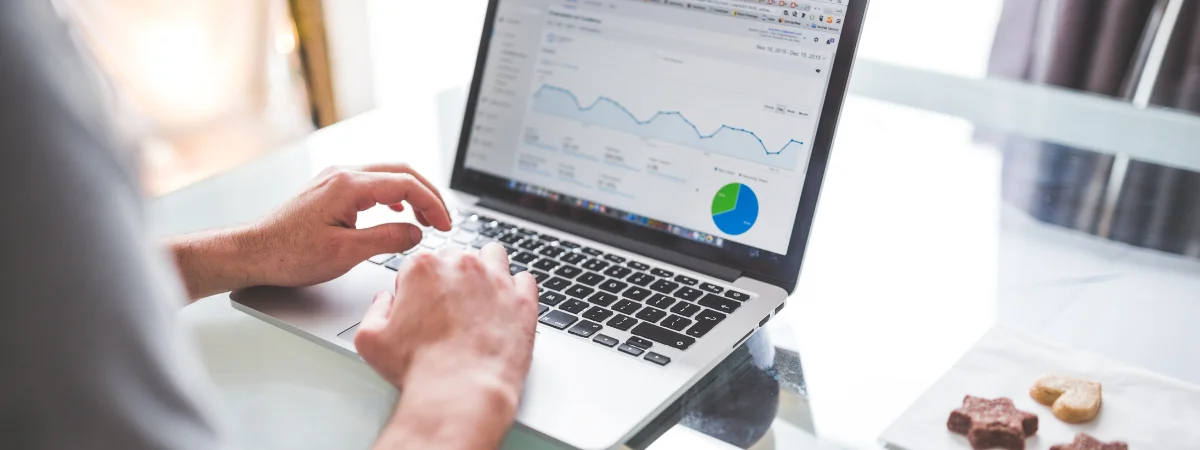 Hands typing on a laptop showing an analytics dashboard