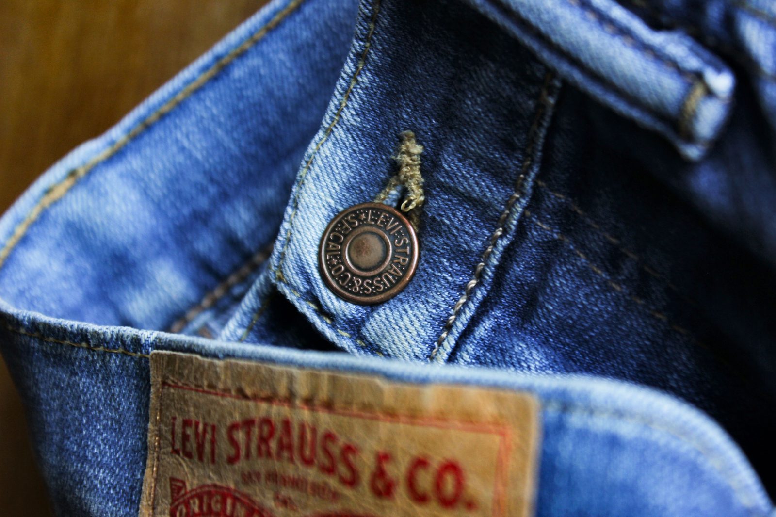 Close-up of a Levi Strauss & Co. leather patch and button on a pair of denim jeans