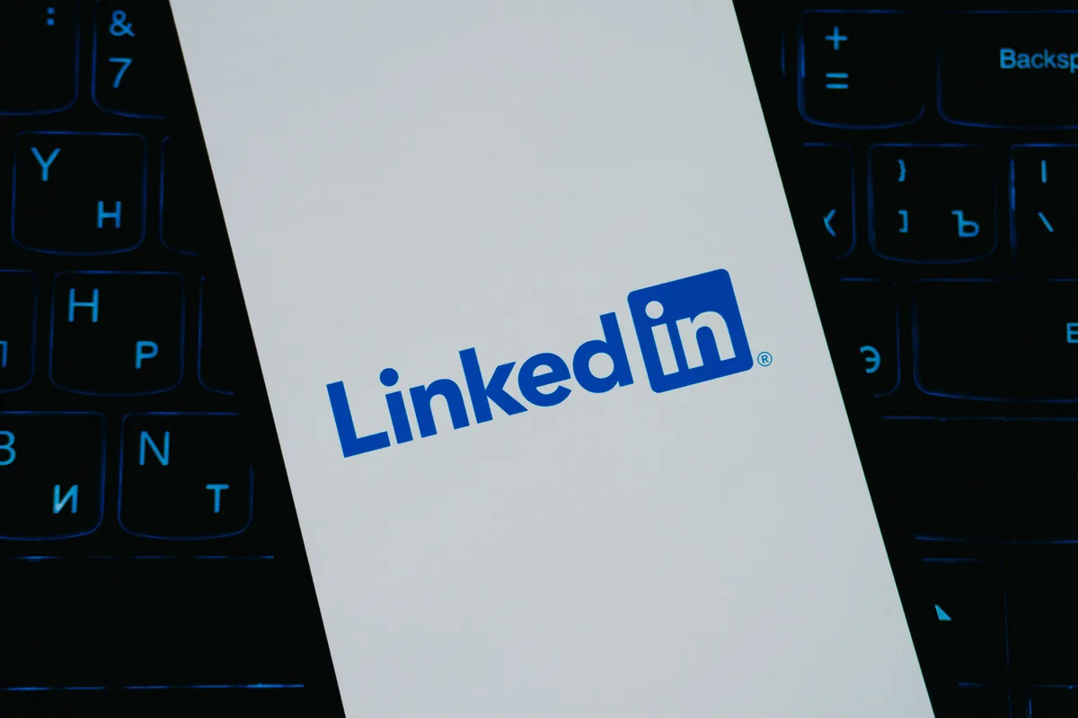 LinkedIn logo on a phone screen lying on a backlit keyboard