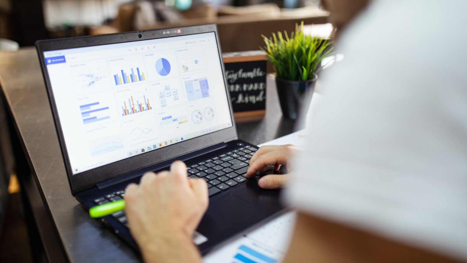 A person using a laptop showing analytics charts and dashboards