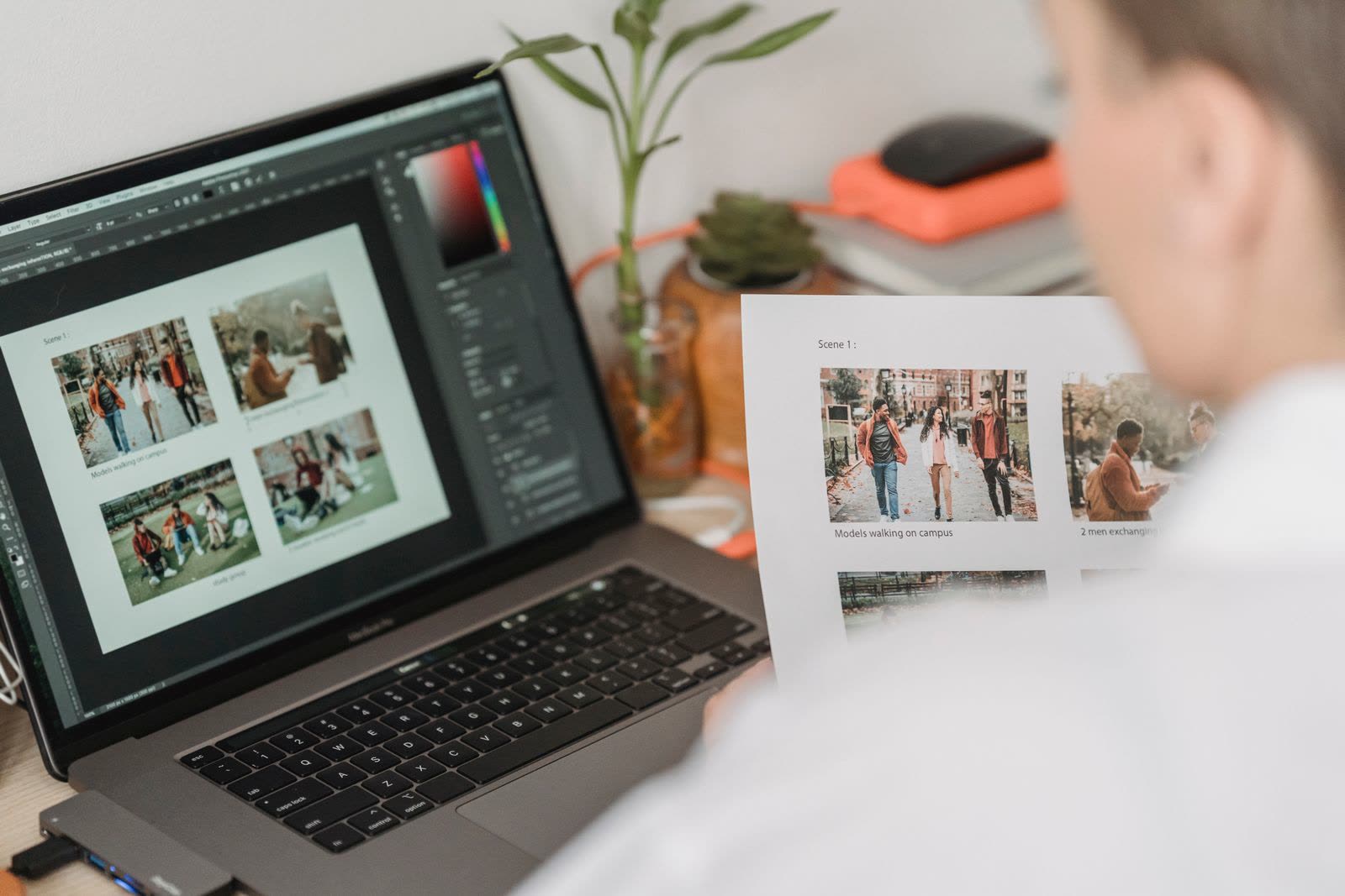 A person at a laptop comparing a grid of campaign photos against printed proofs, the kind of side-by-side creative review the new Meta ads creative breakdown makes possible inside Ads Manager.