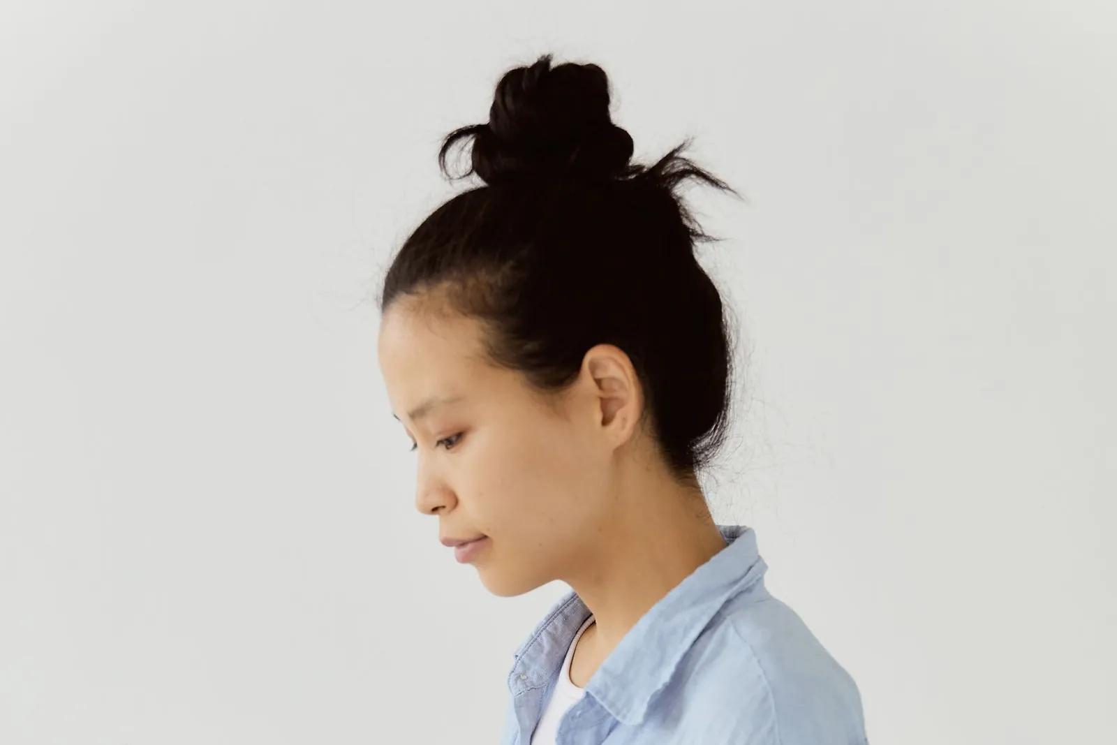 A woman holding a smartphone in one hand and a bank card in the other, weighing up whether a Meta One business subscription is worth paying for.