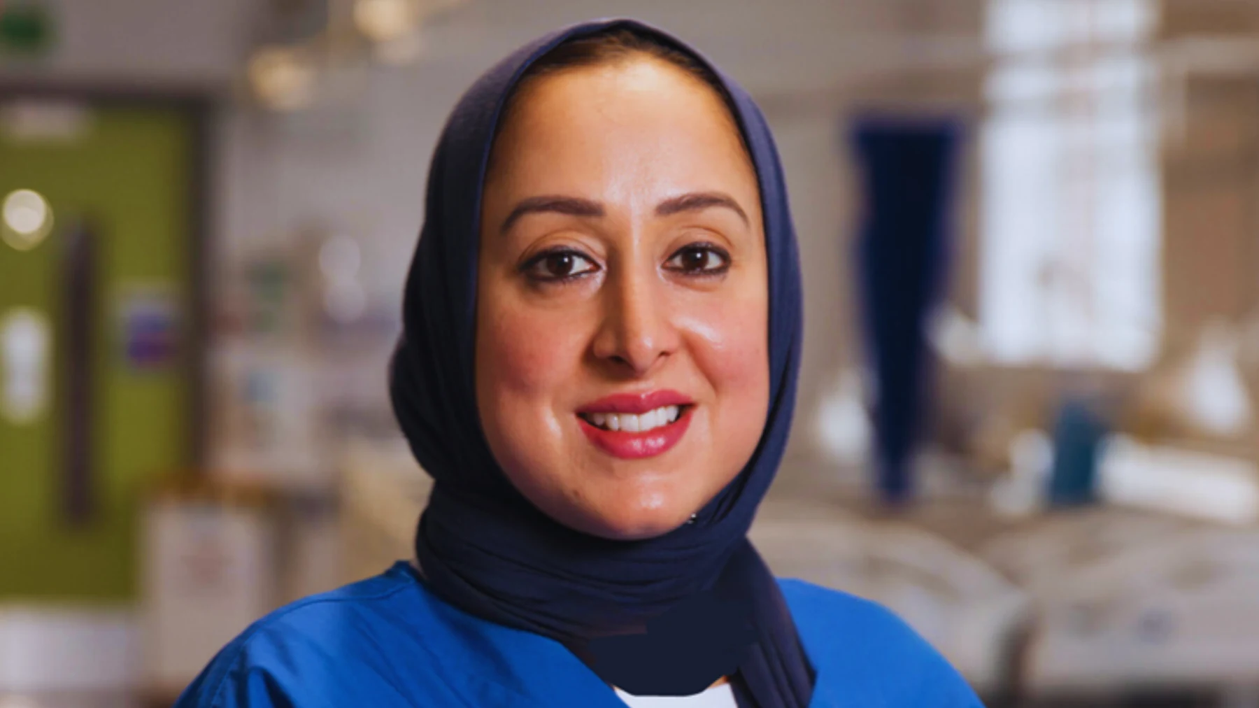 Dr Fareeha Rizvi in blue clinical scrubs and a navy hijab