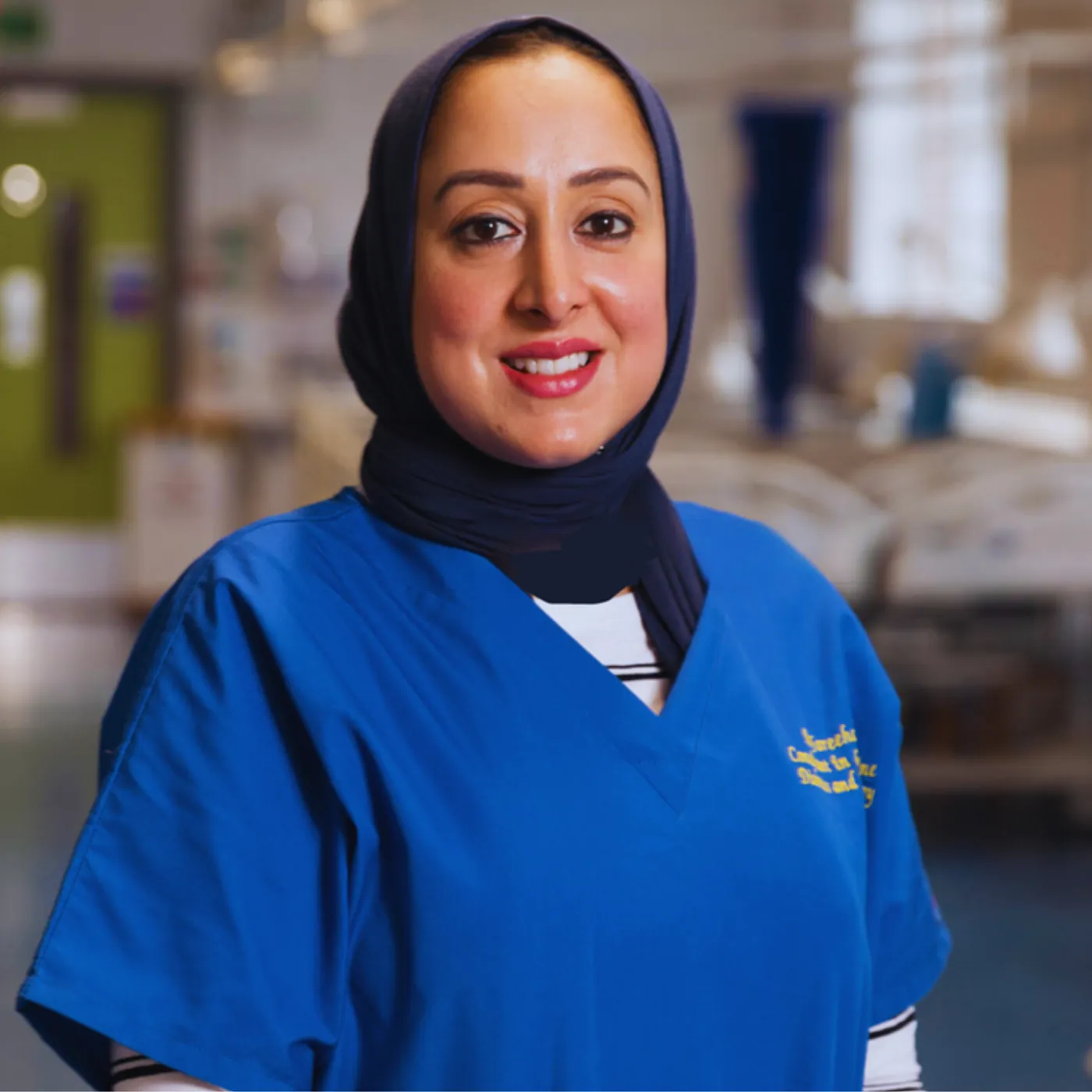 Dr Fareeha Rizvi in blue clinical scrubs and a navy hijab